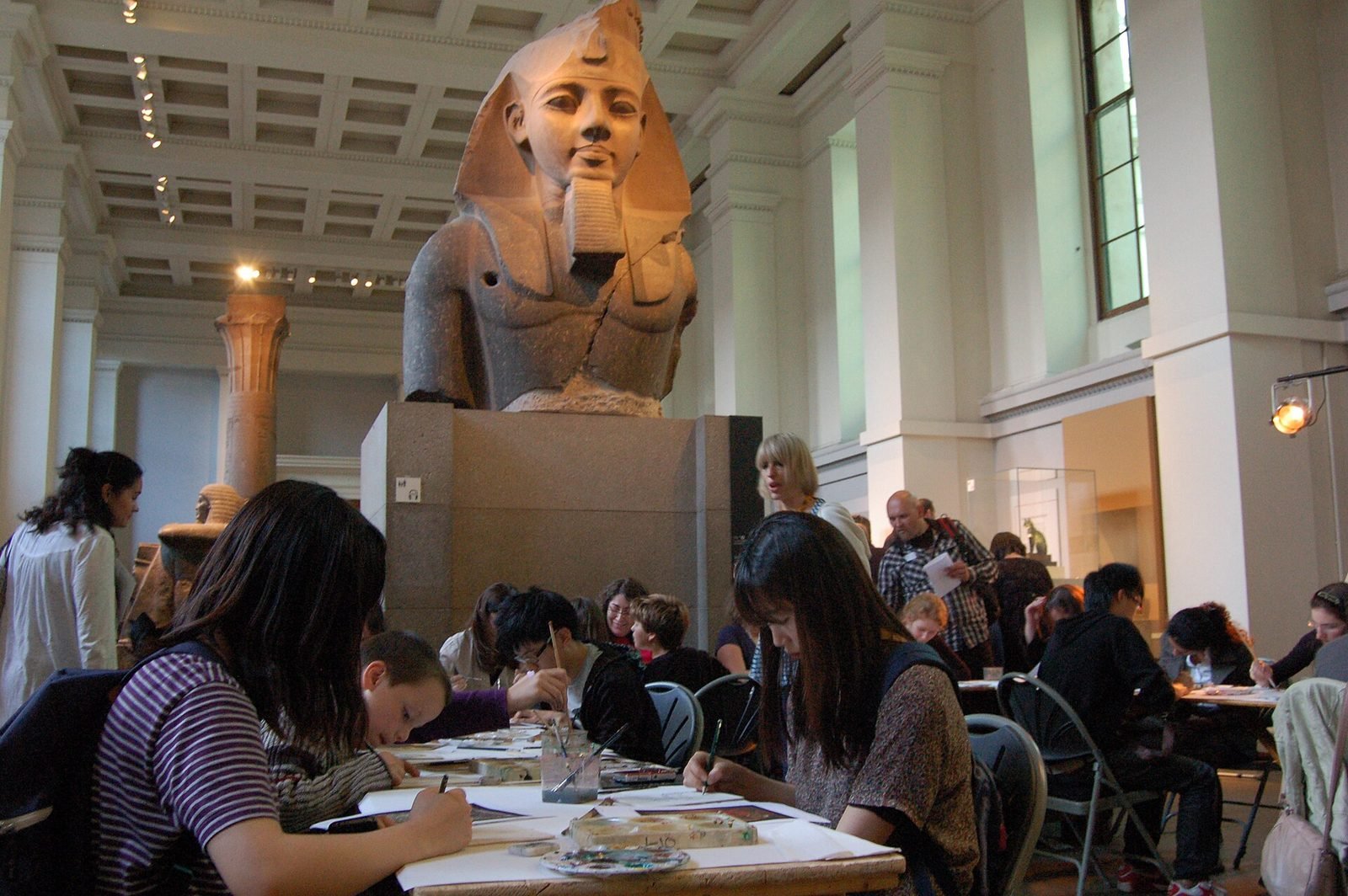 Visitors in a museum gallery with a large sculpture