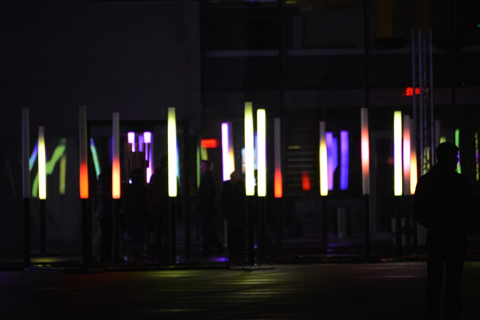 A light installation of glowing coloured columns at night