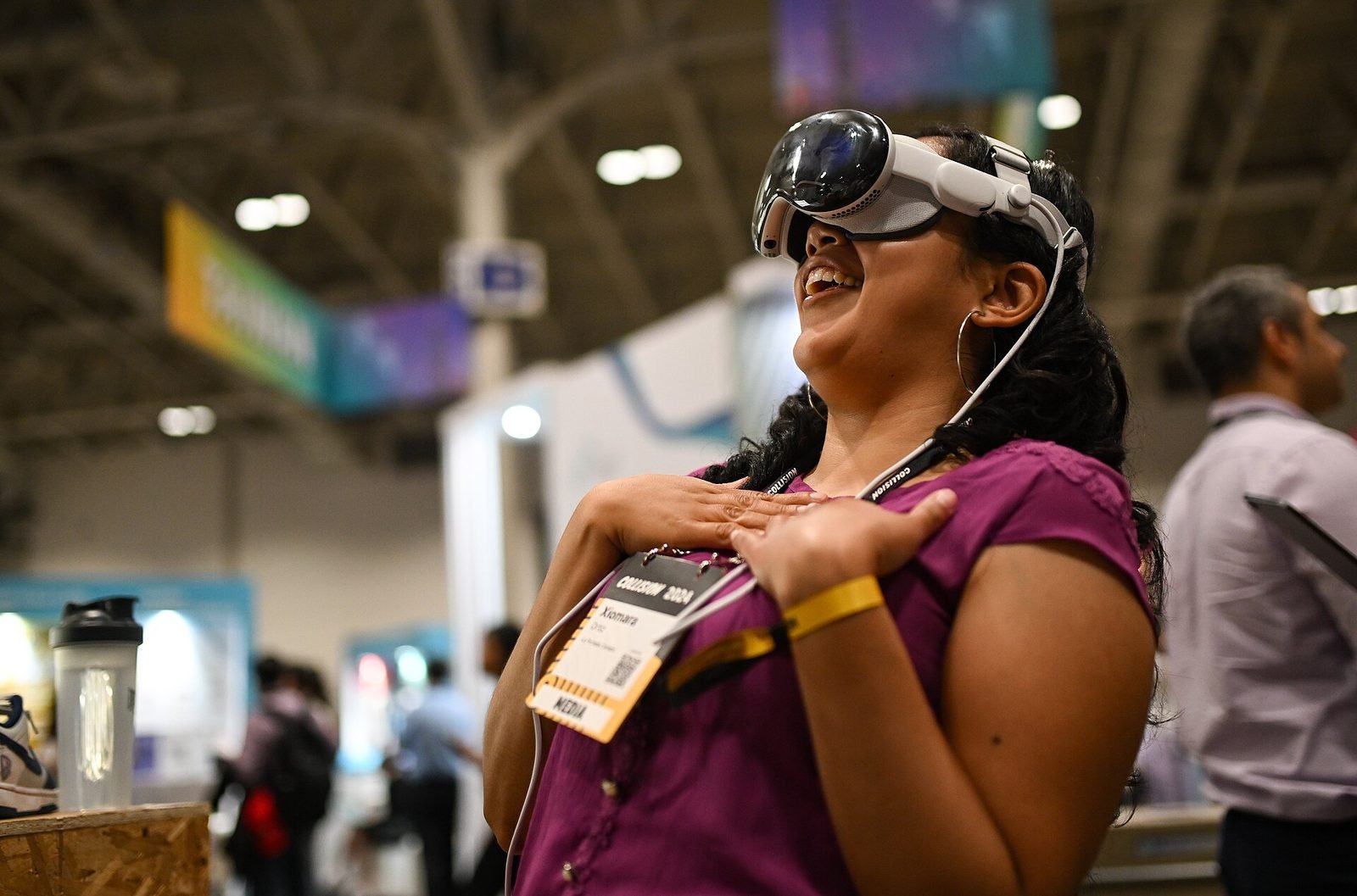 A woman wearing a spatial computing headset, smiling and gesturing
