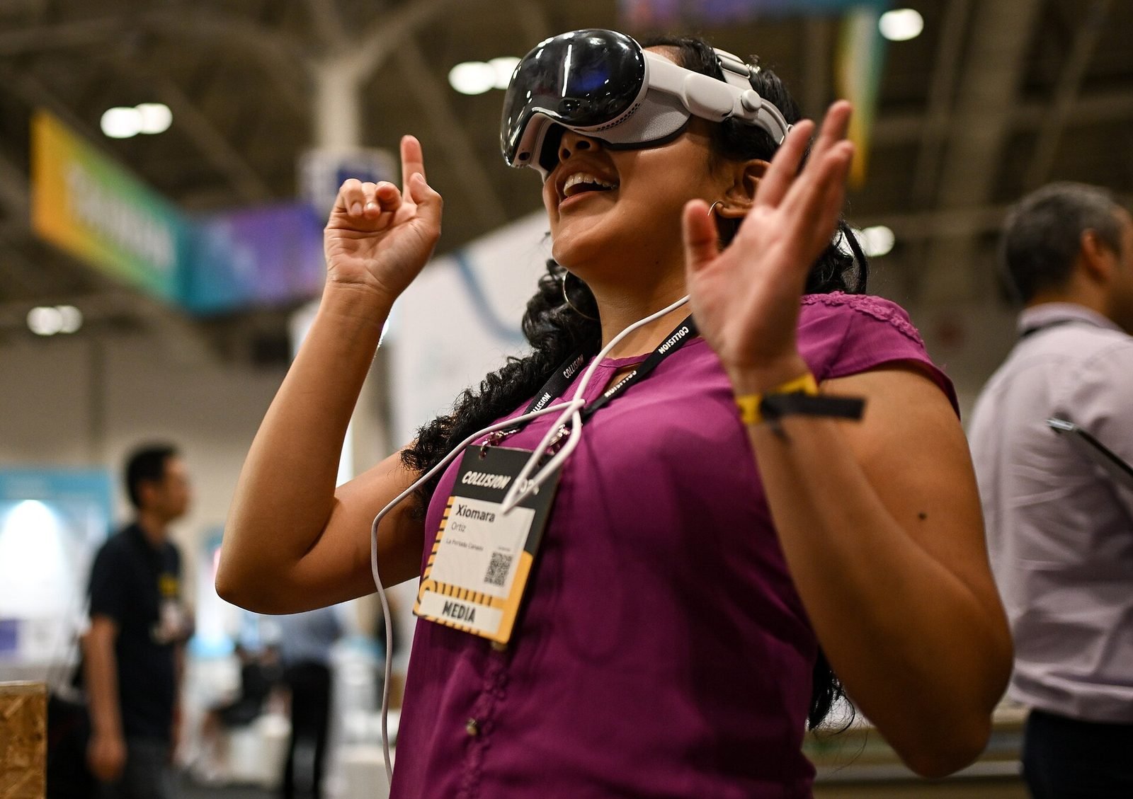 A woman wearing a spatial computing headset, gesturing with her hands