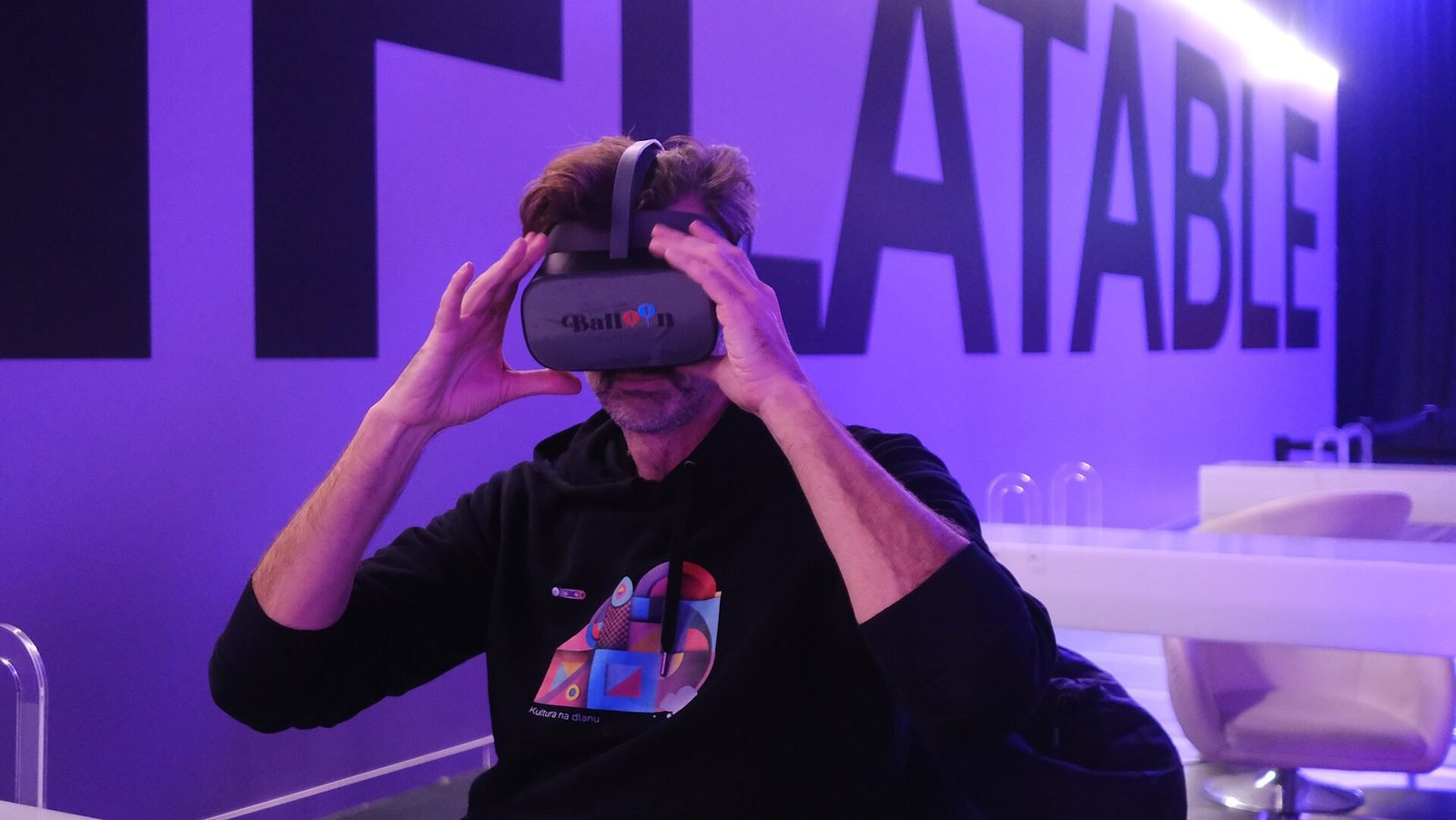 A visitor trying a VR headset inside a colourful museum exhibition